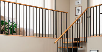 Landing banister with vertical balusters in black with oak handrail